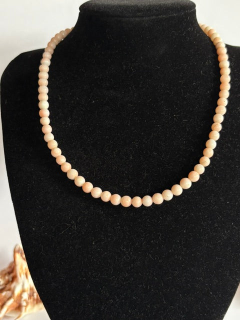 Zarte Vintage-Korallenkette mit rundlichen Perlen in Rosé und Cremeweiß auf Schmuckbüste