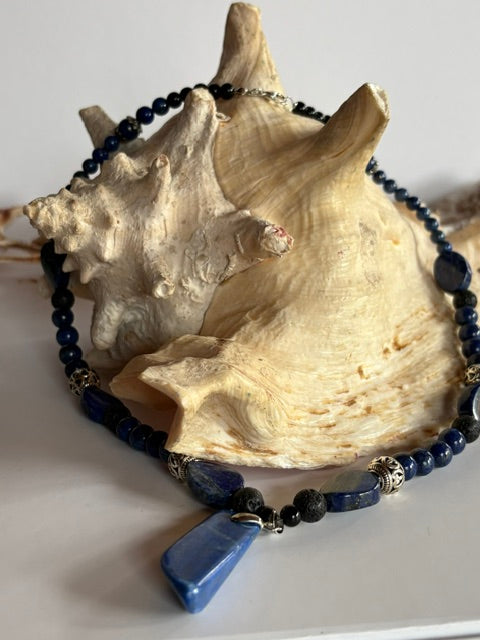 Lapislazuli-Kette mit Steinanhänger und schwarzen Lavaperlen an einer Muschel