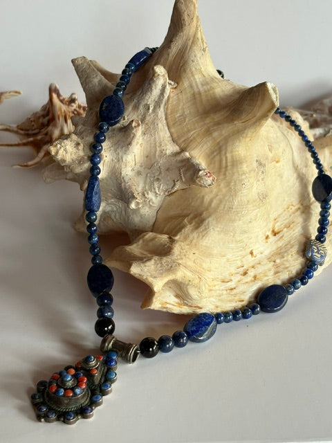 Lapislazuli-Kette mit Vintage-Silberanhänger dekoriert an einer großen Muschel