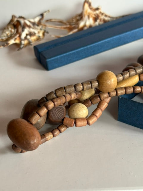 Detail der braunen, ockerfarbenen und beigefarbenen Holzperlen einer dreireihigen Vintage-Kette