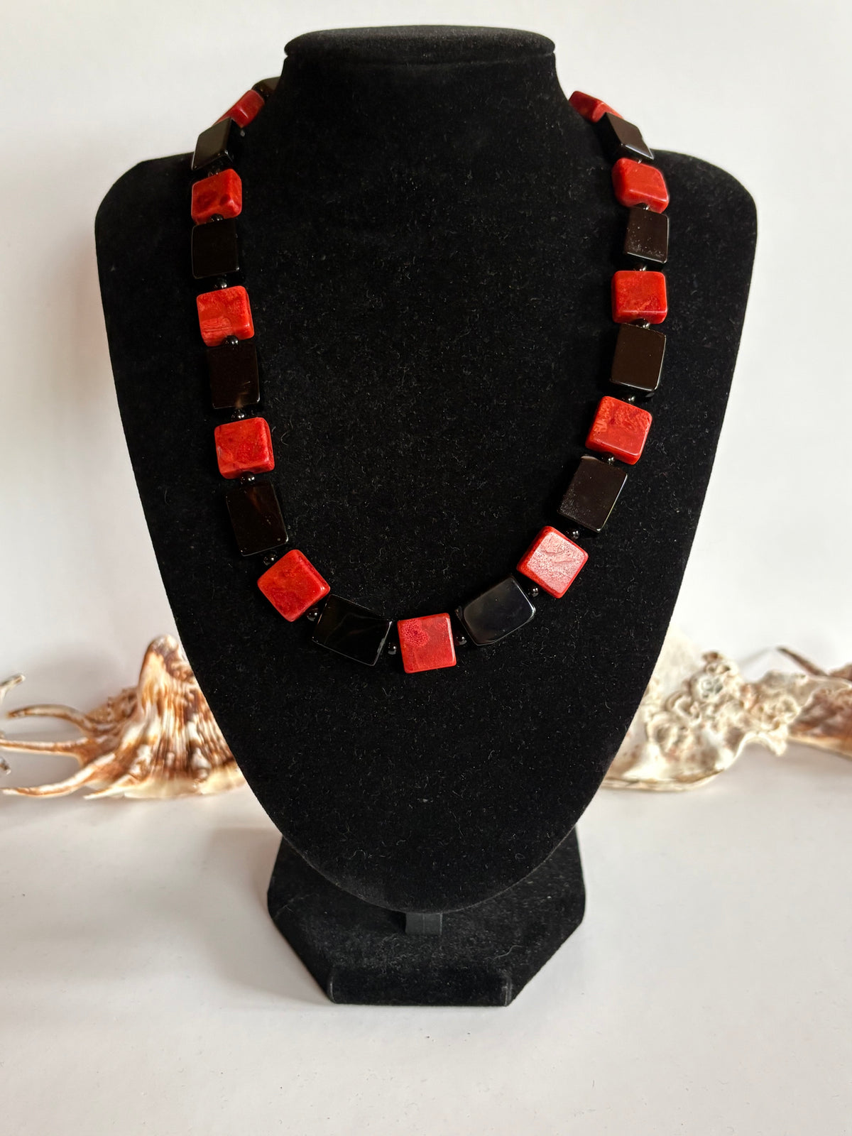 Vintage Korallenkette mit roten Korallenstücken und wahrscheinlich schwarzem Onyx auf Schmuckbüste