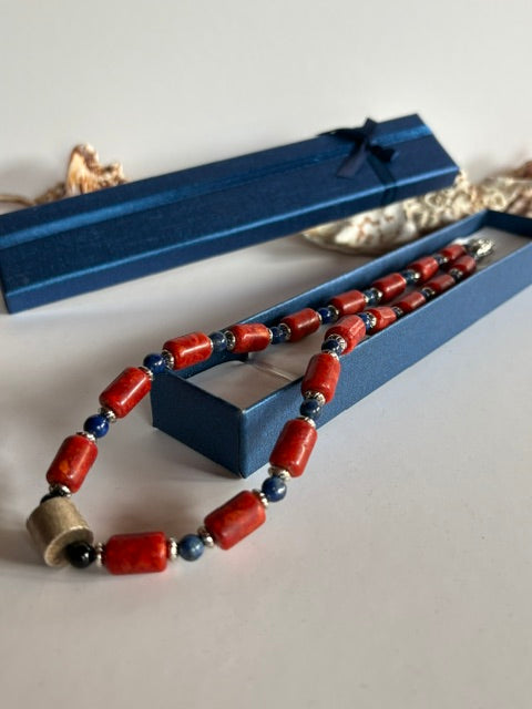 Blaue Lapislazuli-Perlen zwischen Korallenstücken und silberfarbenen Zwischenteilen der handgefertigten Kette