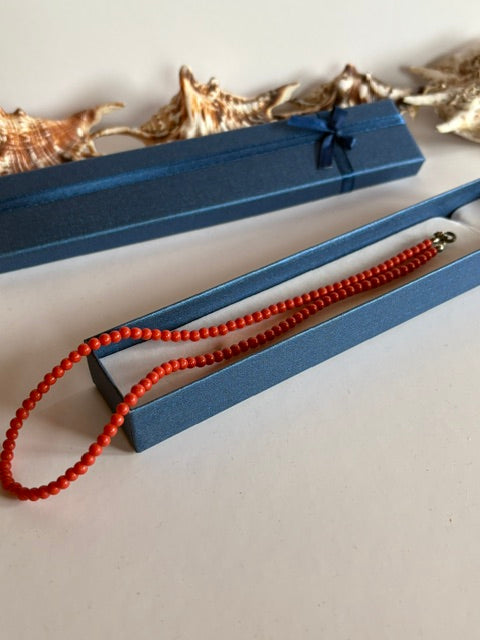 Vintage-Korallenkette dekorativ in einem blauen Schmuckkästchen präsentiert