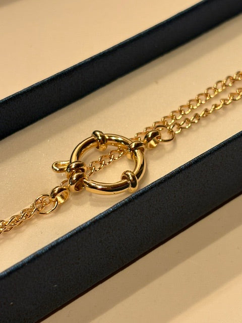 Close-up of the functional gold-tone spring ring clasp on the Golden Cowrie handmade necklace.