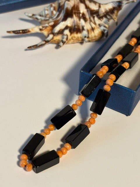 Detailansicht der facettierten Onyxelemente und kleinen orangefarbenen Korallenperlen
