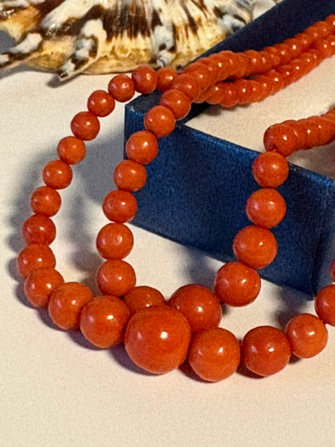 Detailansicht der rundlichen rot-orangen Korallenperlen in abgestufter Größe