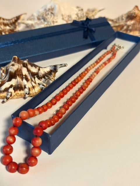 Vintage-Korallenkette in warmen Rottönen in einer blauen Schmuckschachtel