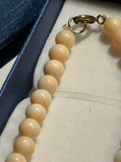Detailansicht des goldfarbenen Karabinerverschlusses der roséfarbenen Vintage-Korallenkette