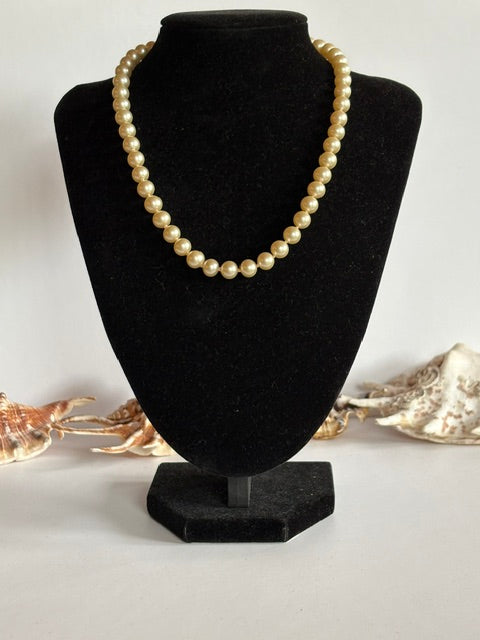 Elegante Vintage-Perlenkette mit cremefarbenen Kugelperlen auf schwarzer Schmuckbüste