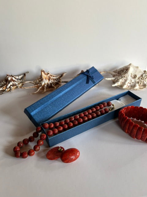 Vintage-Schaumkorallen-Set mit Halskette über einer blauen Schmuckschachtel, Armband und ovalen Ohrsteckern