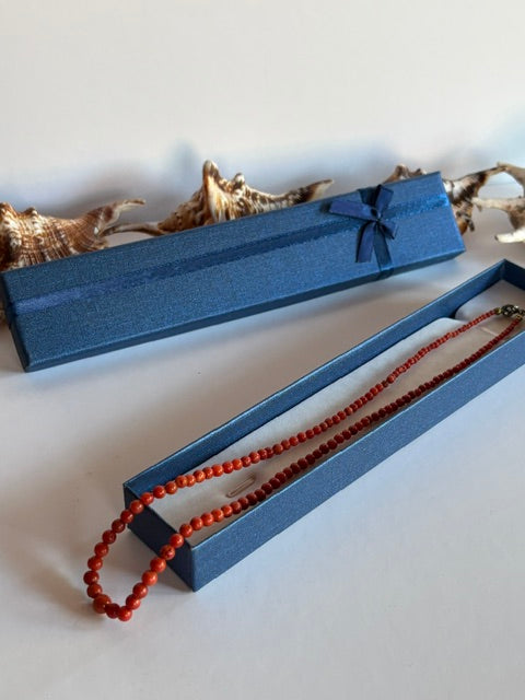 Feine Korallenperlenkette mit leichtem Größenverlauf in geöffneter Schmuckbox