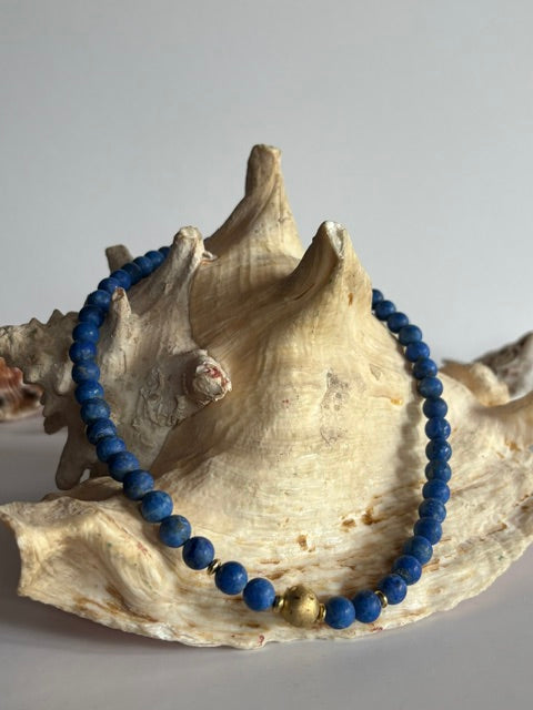 Kurze Vintage-Lapislazuli-Kette dekoriert auf einer großen Muschel