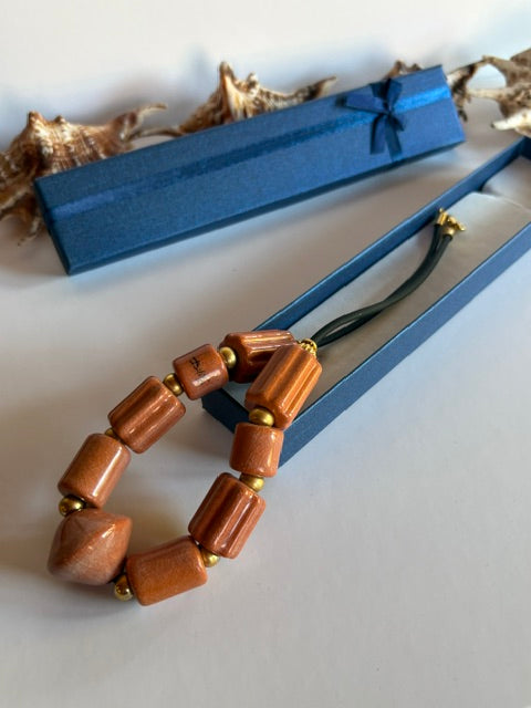 Goldfarbener Karabinerverschluss und schwarzes gummiartiges Band des Colliers