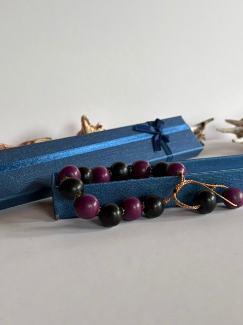 Verstellbares Vintage-Armband in Schwarz und Violett vor einer blauen Schmuckschachtel