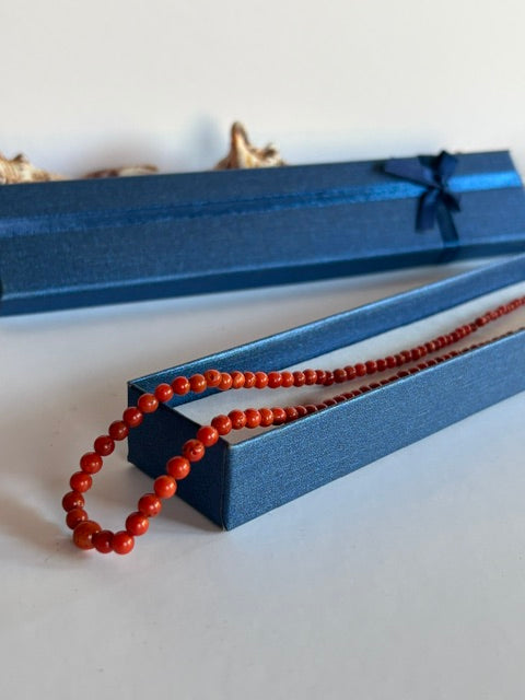 Vintage-Korallenkette mit roten Perlen in einer blauen Schmuckschachtel