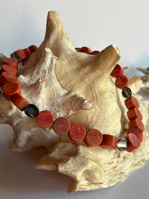 Rotorange Schaumkorallenkette mit natürlichen Poren dekorativ auf einer Muschel