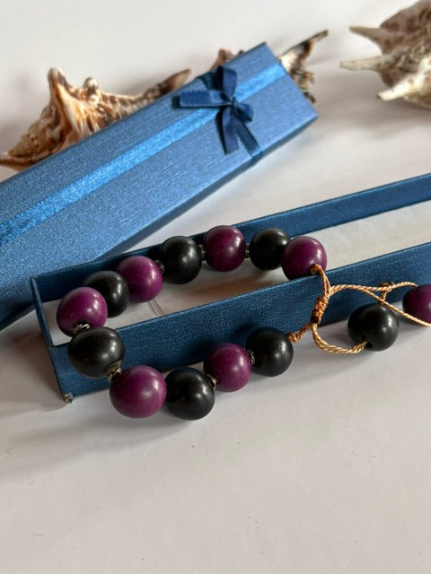 Vintage-Perlenarmband mit glatten schwarzen und violetten Kugeln auf goldbrauner Kordel