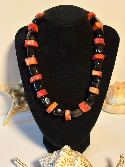 Vintage-Korallenkette mit Onyx auf einer Büste präsentiert.