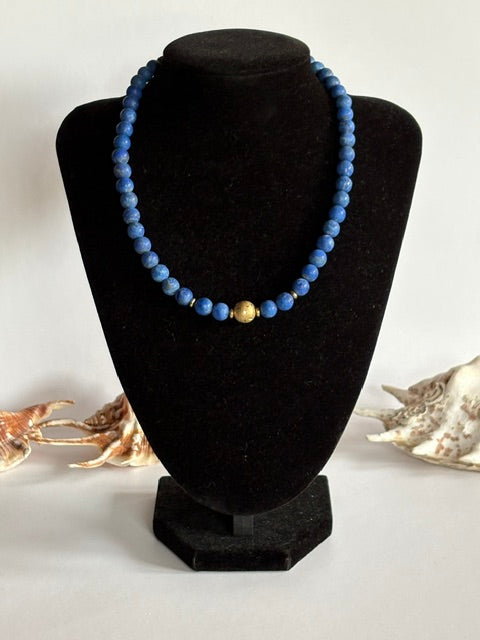 Blaue Lapislazuli-Kette mit goldfarbener Mittelkugel auf Schmuckbüste