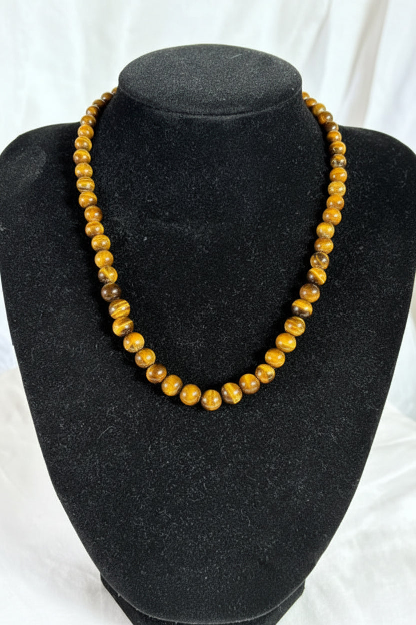 Vintage Tigerauge Halskette aus echtem Tigerauge auf schwarzer Schmuckbüste präsentiert. Eleganter Natursteinschmuck mit goldbraunen Tigerauge-Perlen und natürlichem Schimmer.