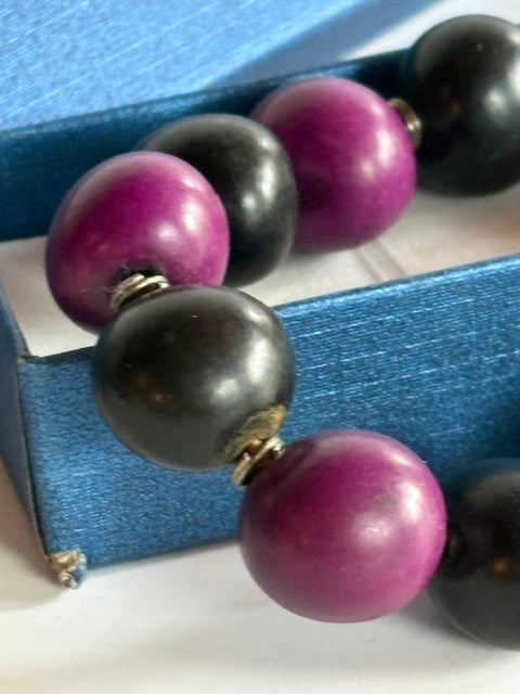 Nahaufnahme der glatten schwarzen und violetten Perlen mit silberfarbenen Zwischenelementen